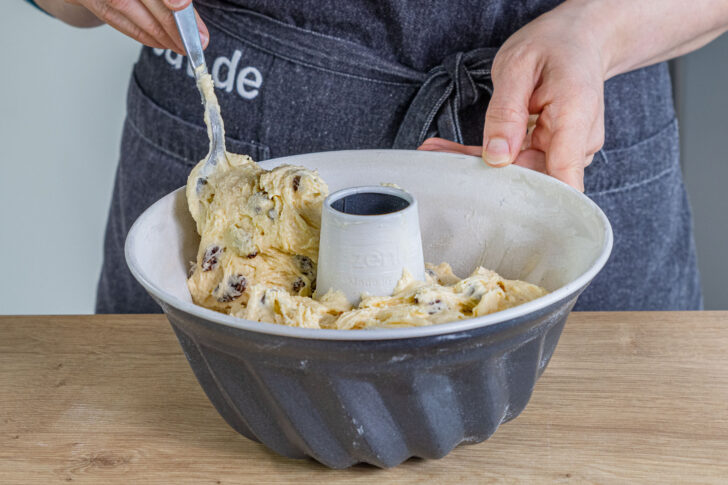 Teig für Gugelhupf mit Rosinen in die Form geben