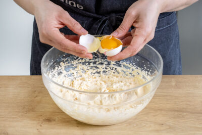 Ei zur aufgeschlagenen Butter geben