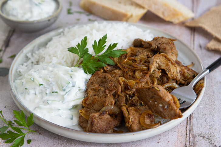 Das Gyros mit dem Reis und Zaziki servieren.