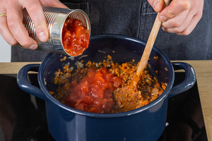 gehackte Tomaten in den Topf geben