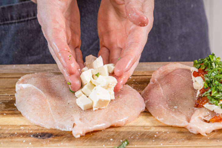 Käse auf die Hähnchenbrust geben