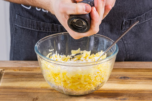 Kartoffelraspeln mit Pfeffer würzen