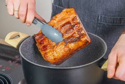 Kasslerbraten aus dem Bräter nehmen