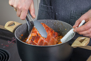 Kasslerbraten aus dem Topf holen
