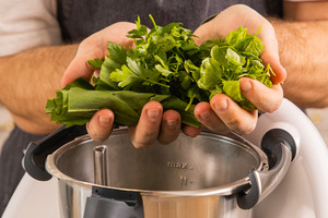 Kräuter und Frühlingszwiebeln in den Thermomix® geben