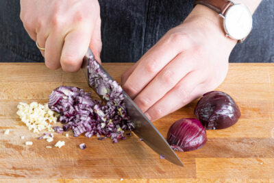 Zwiebel und Knoblauch in deine Würfel hacken