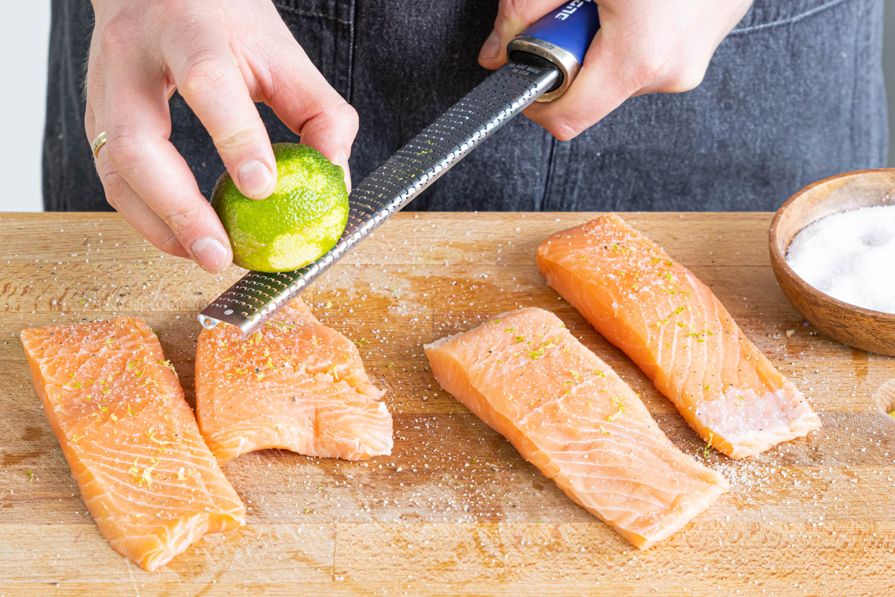 Limettenschale über die Lachsfilet reiben