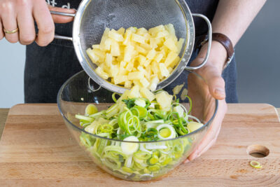 Ananas abtropfen lassen und zum Lauch geben