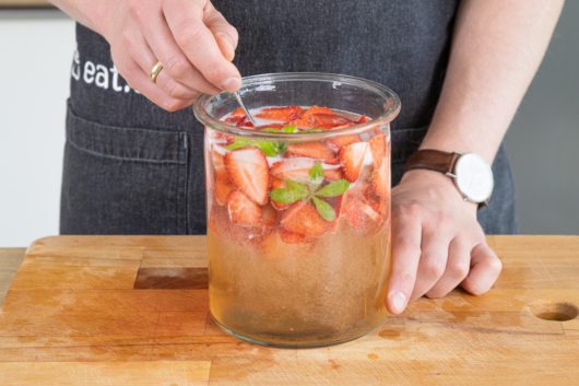 Maibowle mit Erdbeeren umrühren
