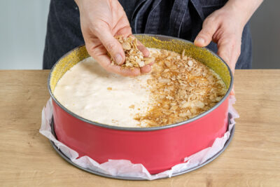 Mandelsplitter, Zimt und braunen Zucker über den Milchreiskuchen streuen