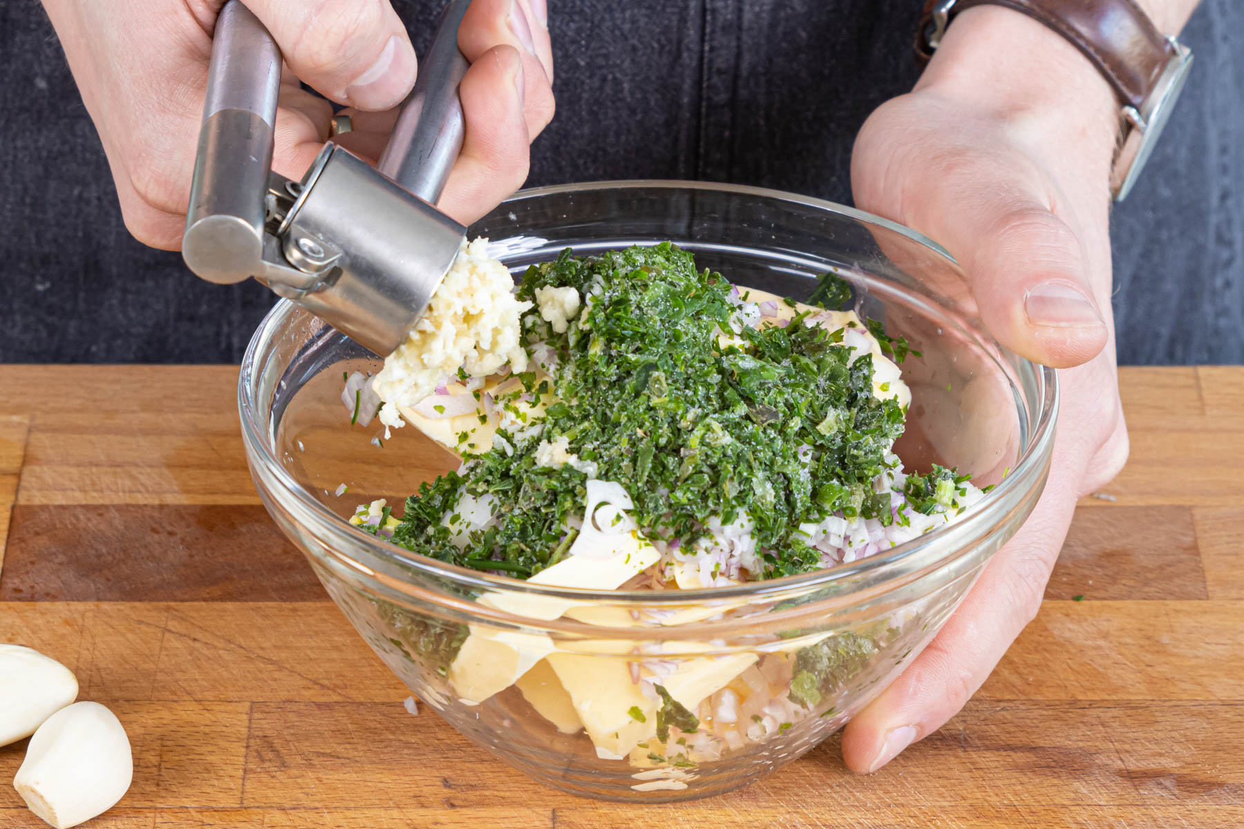 gepressten Knoblauch und Kräuter zur Butter geben