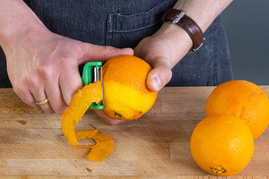 Orangen mit einem Sparschäler schälen
