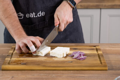 Den Feta in Würfel, und die Zwiebel in Streifen schneiden. 