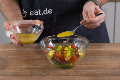 Die Avocado und Tomate mit der Vinaigrette zusammengeben.