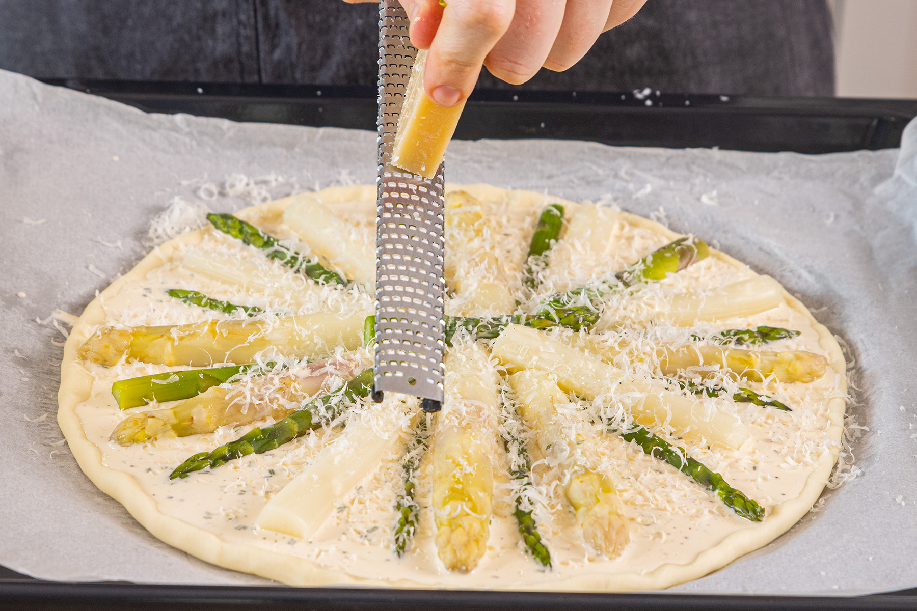 Parmesan über der schnellen Spargeltarte verteilen