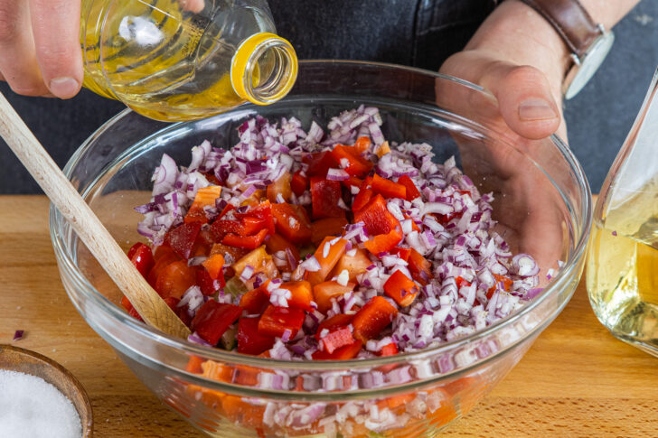 Öl zum Schopska-Salat geben