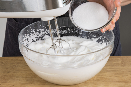 Etwas Zucker zum Eischnee geben