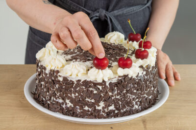 Schwarzwälder Kirschtorte mit Kirschen dekorieren