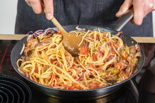 Spaghetti mit Thunfischsoße vermischen
