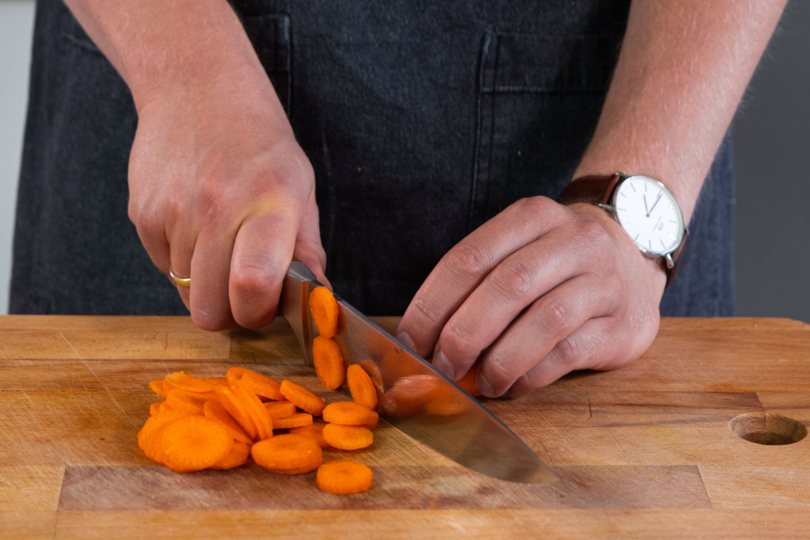 Karotten werden in kleine Scheiben geschnitten.