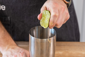 Limette ausdrücken und Saft in den Shaker geben