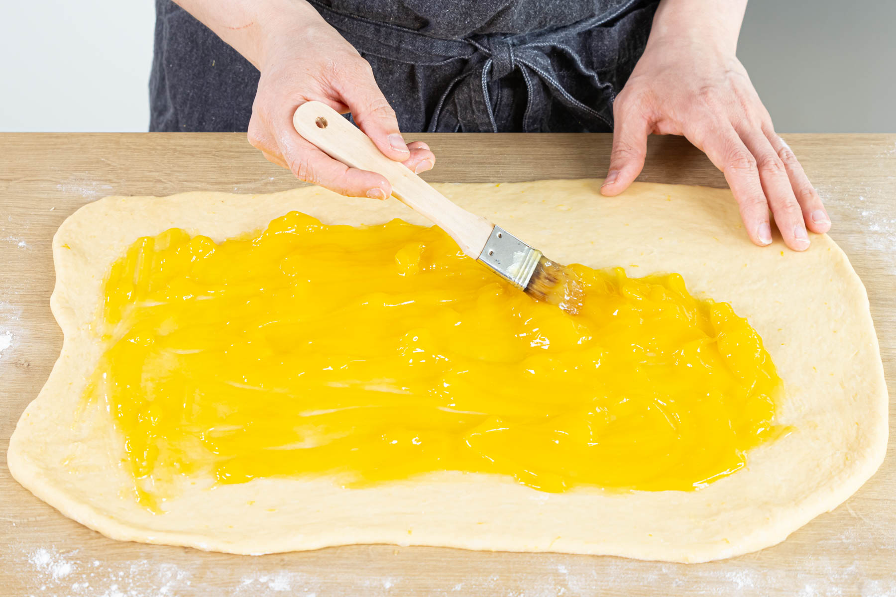Hefeteig mit Lemon Curd bestreichen und zusammenrollen