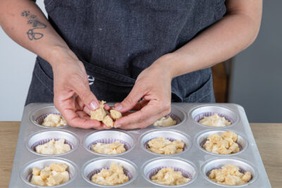 Streusel über Apfelmuffins geben