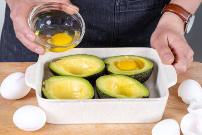 Eier in die Avocados geben