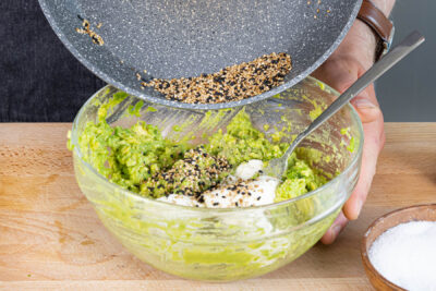 Frischkäse und Sesam zur Avocadocreme geben