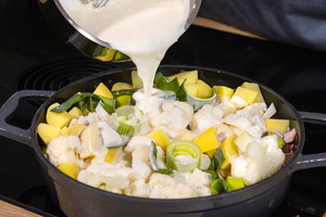 Blumenkohlauflauf mit Kartoffeln und Schinken mit Soße bedecken
