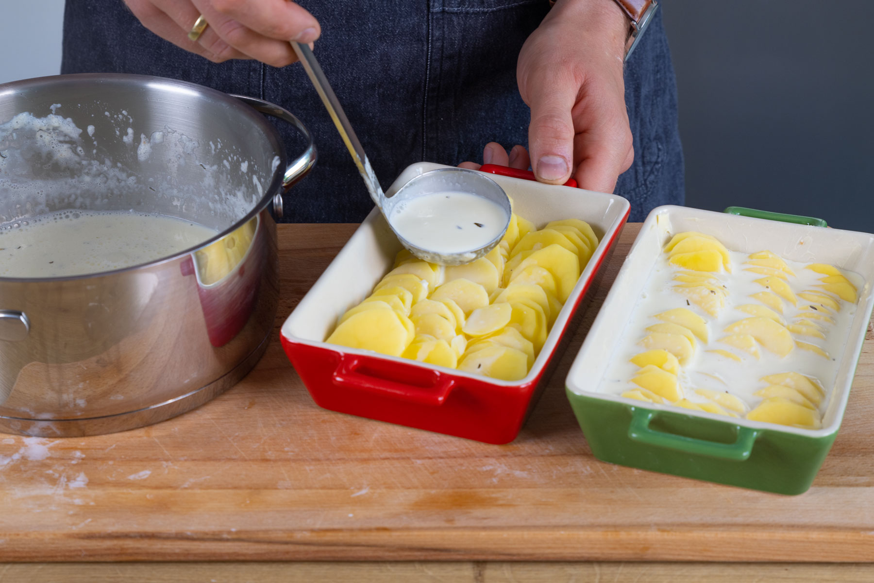Die Sahnesauce über das weltbeste Kartoffelgratin geben
