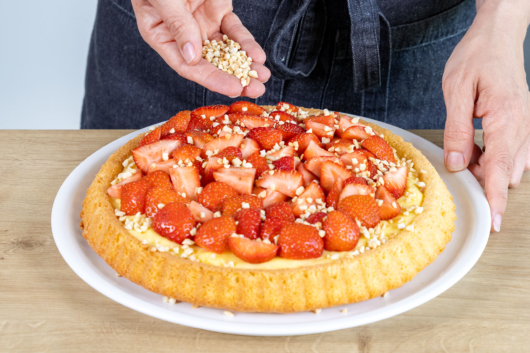 Erdbeerkuchen mit Pudding mit gehackten Mandeln bestreuen
