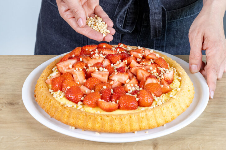 Erdbeerkuchen mit Pudding mit gehackten Mandeln bestreuen
