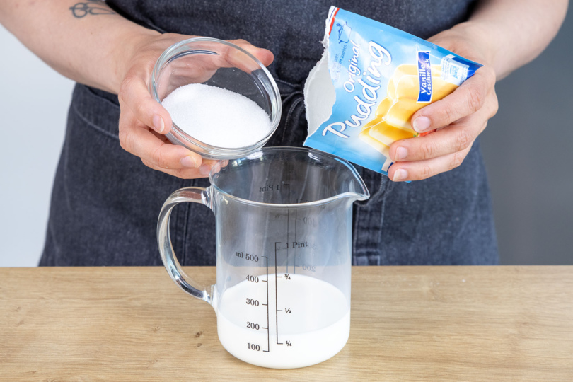Zucker und Puddingpulver zur Milch geben