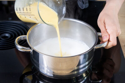 angerührtes Puddingpulver zu Milch geben