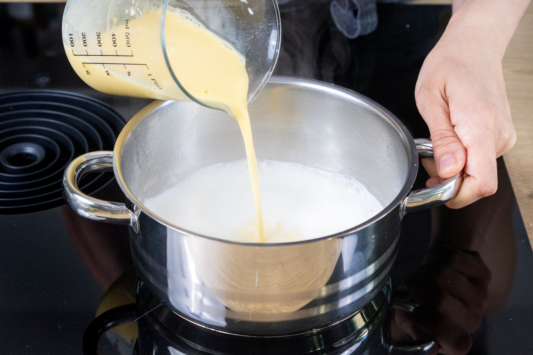 angerührtes Puddingpulver zu Milch geben
