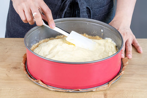 Puddingcreme auf den Keksboden der Erdbeertorte geben