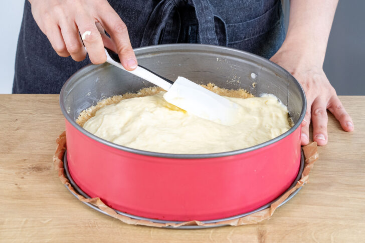 Puddingcreme auf den Keksboden der Erdbeertorte geben
