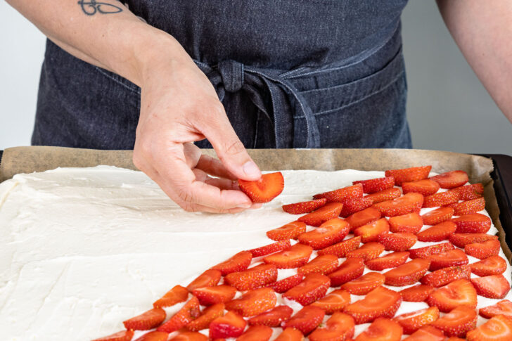 Erdbeeren auf Sahnecreme verteilen