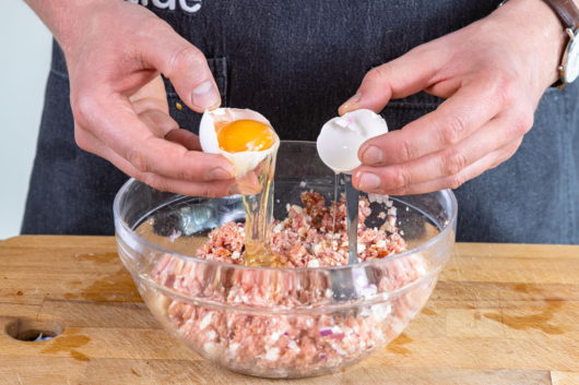 Ei zur Hackfleisch-Feta-Masse geben