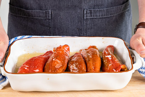gefüllte Spitzpaprika mit Hackfleisch aus dem Ofen nehmen