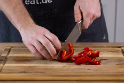 Paprika in feine Streifen schneiden.