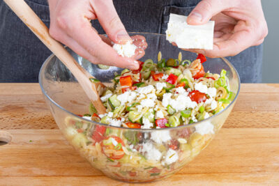 Feta über den griechischen Kritharaki-Salat bröseln