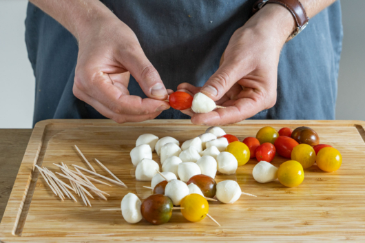 Tomate und Mozzarella auf Zahnstocher spießen