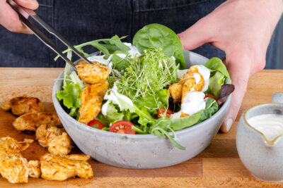 Hähnchen auf den Salat geben