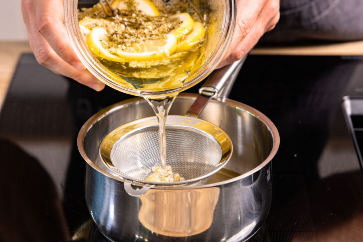 Holunderblütensirup durch Sieb abgießen