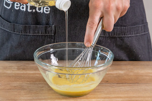 Öl zum Honig-Senf-Dressing gießen und verrühren