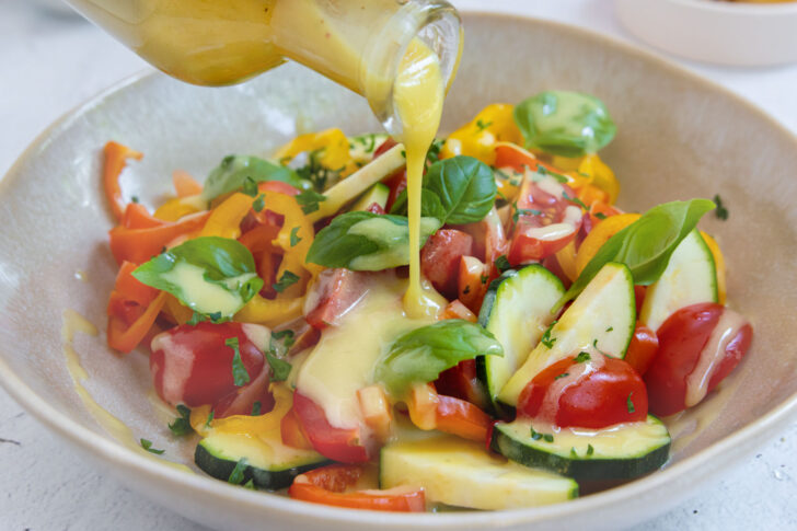 Honig-Senf-Dressing auf Salat gießen