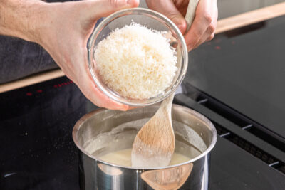 Parmesan in den Topf geben