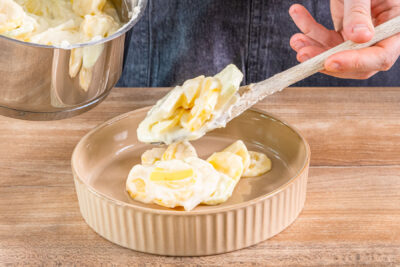 Kartoffel-Kohlrabi-Gratin in eine Auflaufform füllen